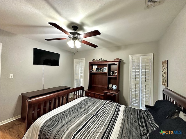 bedroom featuring wood-type flooring, ceiling fan, and a textured ceiling