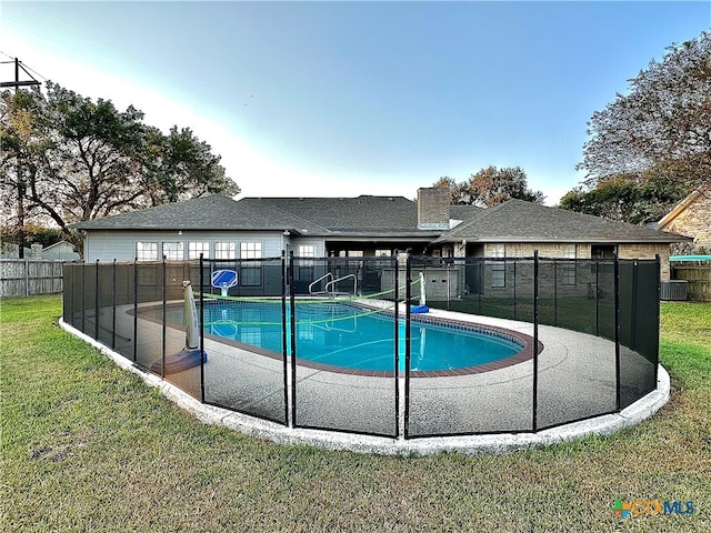 view of pool featuring central AC and a yard