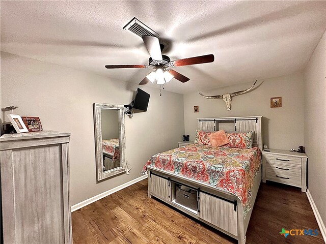 bedroom with a textured ceiling, dark hardwood / wood-style flooring, and ceiling fan