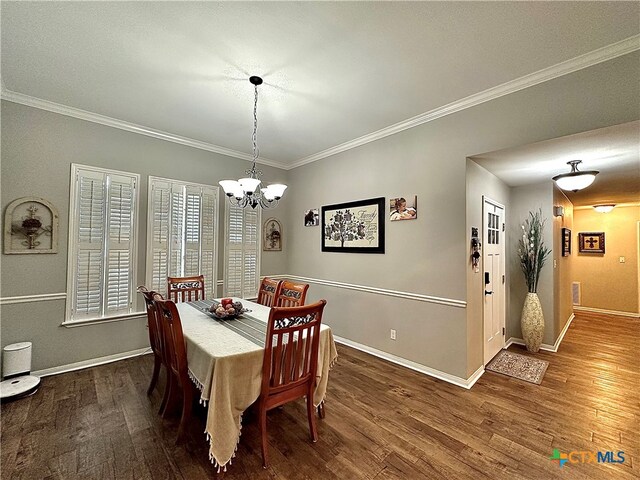 dining area featuring ornamental molding, dark hardwood / wood-style flooring, and a notable chandelier