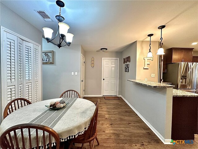 dining room featuring dark wood-type flooring and an inviting chandelier