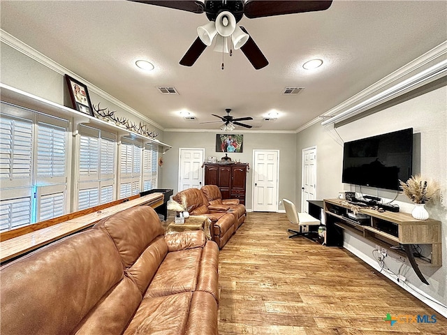 living room featuring ceiling fan, a textured ceiling, light hardwood / wood-style floors, and crown molding