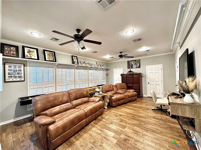 living room with ornamental molding, light hardwood / wood-style flooring, a textured ceiling, and ceiling fan