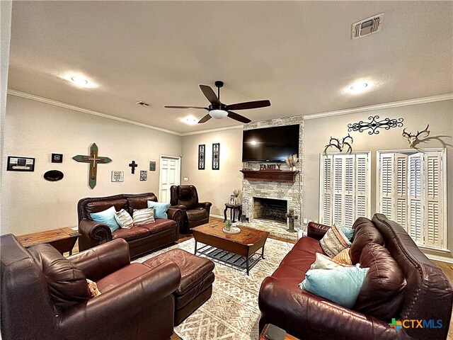 living room with a fireplace, ceiling fan, and ornamental molding