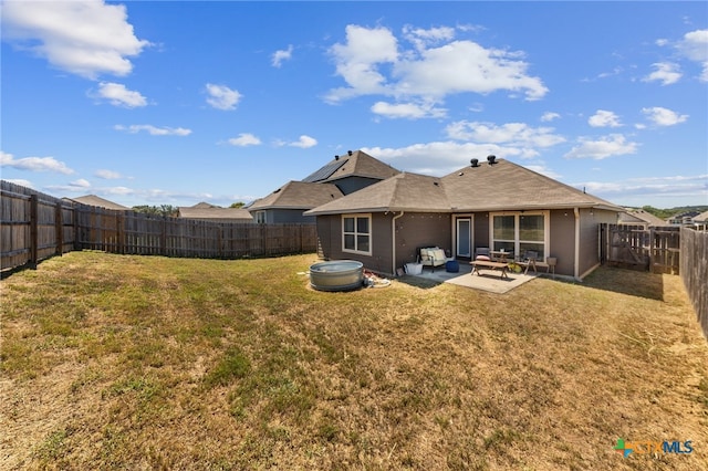 rear view of house with a patio and a yard