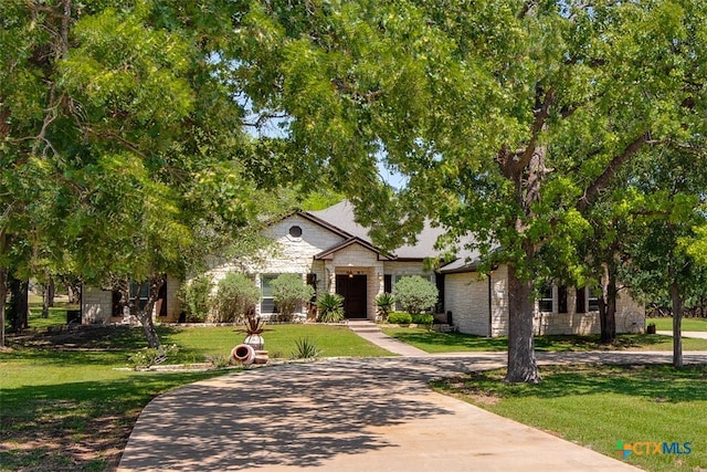 view of property hidden behind natural elements with a front yard