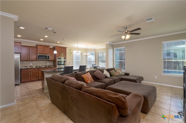 tiled living room featuring a healthy amount of sunlight, ornamental molding, and ceiling fan with notable chandelier