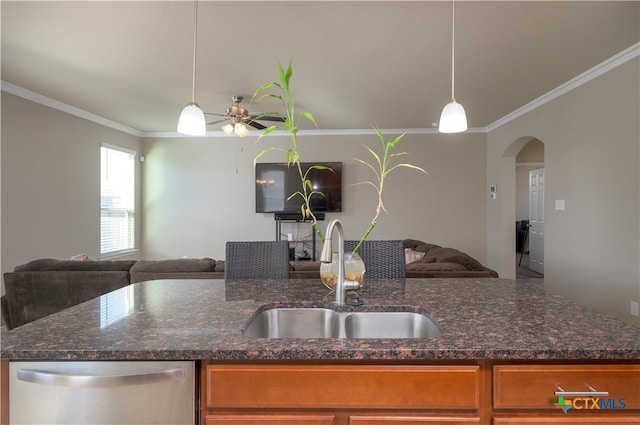 kitchen with dishwasher, sink, dark stone counters, and decorative light fixtures