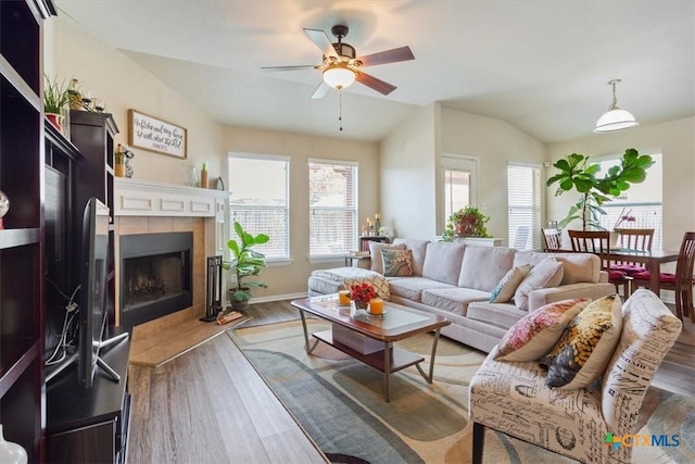 212 Nairm Ln, Temple, TX 76502 - living room featuring ceiling fan, wood finished floors, vaulted ceiling, a tile fireplace, and baseboards