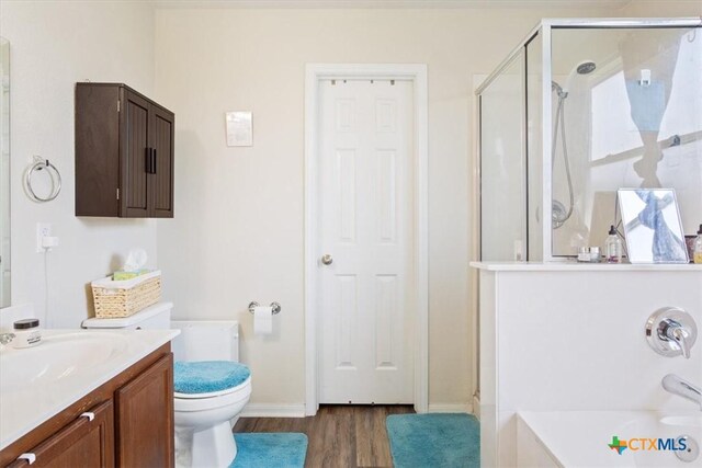 212 Nairm Ln, Temple, TX 76502 - full bathroom featuring wood finished floors, a stall shower, vanity, toilet, and a garden tub