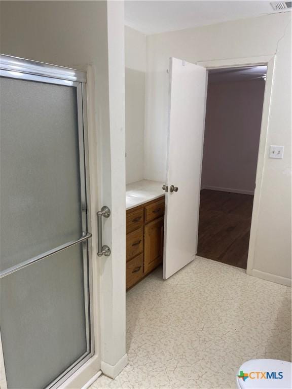 bathroom featuring a stall shower, baseboards, and visible vents