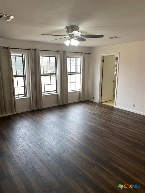 empty room with dark wood finished floors and visible vents