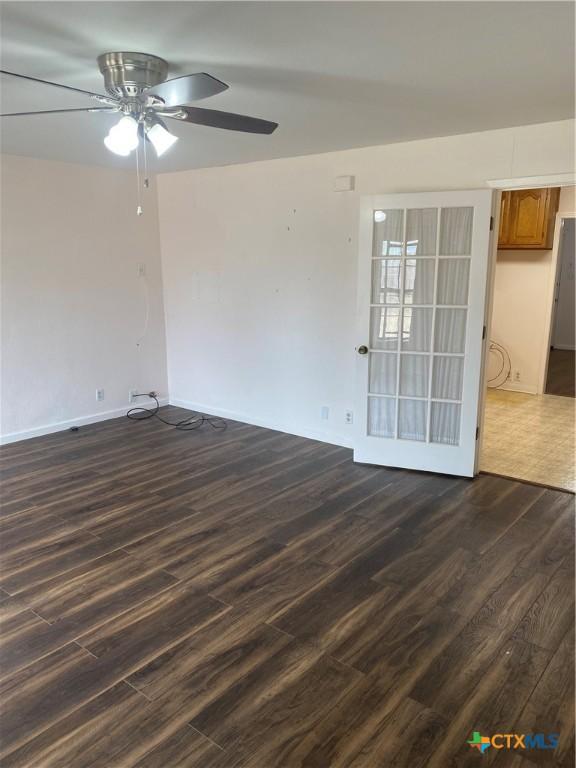 unfurnished room with a ceiling fan and dark wood finished floors