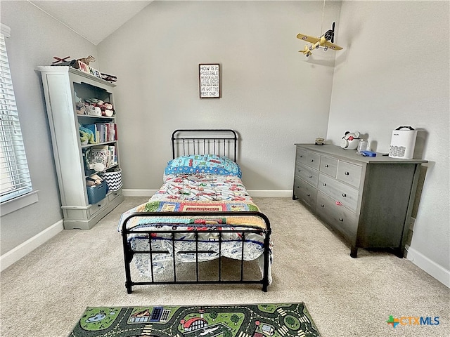 bedroom featuring lofted ceiling and light colored carpet