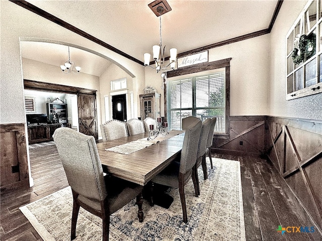 dining space with ornamental molding, dark wood-type flooring, a chandelier, and lofted ceiling