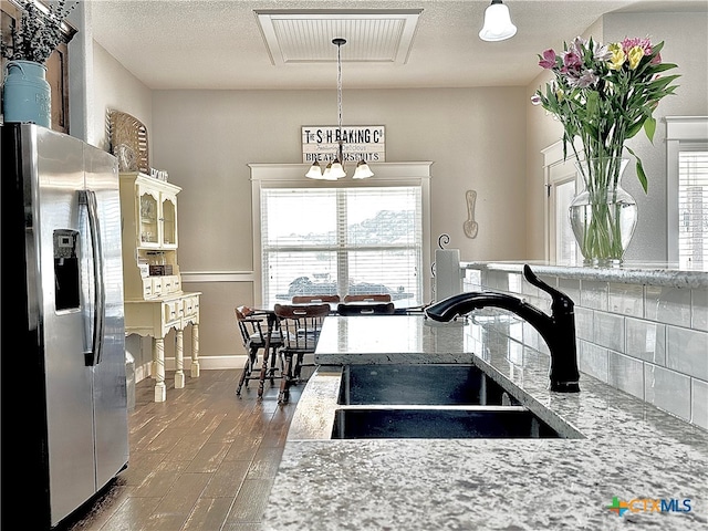 kitchen with dark hardwood / wood-style flooring, sink, stainless steel fridge with ice dispenser, and plenty of natural light