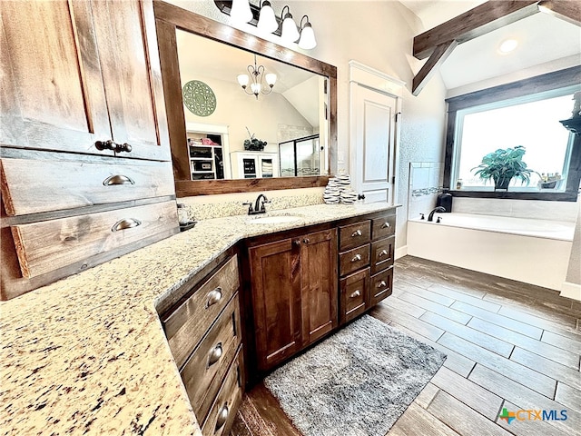 bathroom with lofted ceiling with beams, vanity, hardwood / wood-style floors, and a bathtub