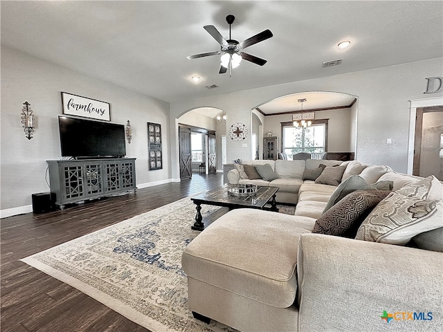 living room with dark wood-type flooring and ceiling fan with notable chandelier