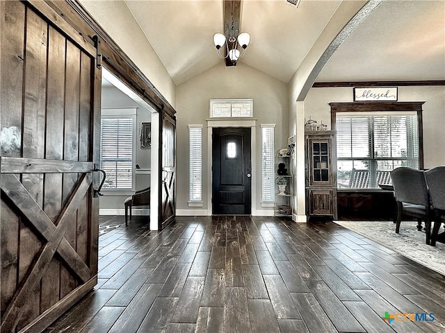 foyer with dark hardwood / wood-style flooring, a barn door, and lofted ceiling with beams