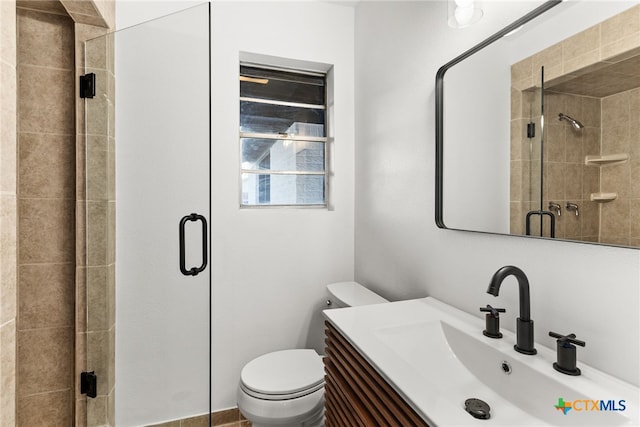 bathroom with toilet, a shower with door, and vanity