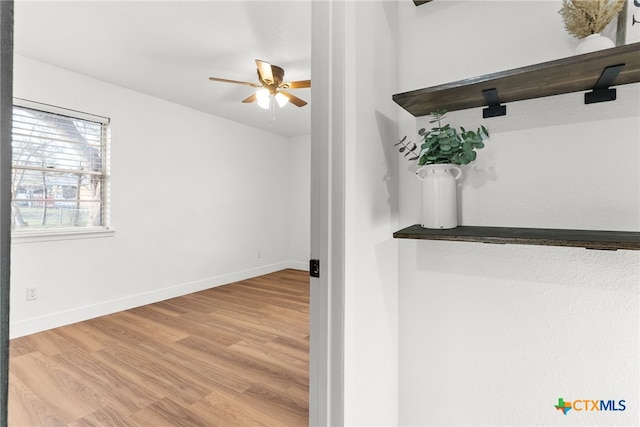 interior space with ceiling fan, bar area, and light hardwood / wood-style flooring