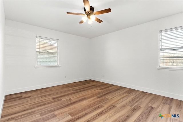 empty room with ceiling fan and hardwood / wood-style floors