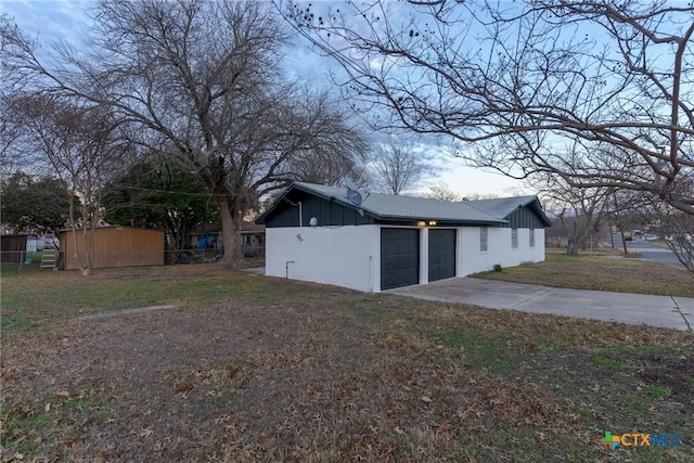 view of side of home featuring a lawn and a garage