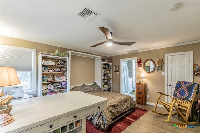 bedroom featuring ceiling fan, crown molding, and wood-type flooring