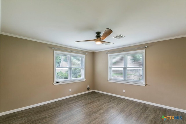 unfurnished room with dark wood-style floors, baseboards, visible vents, ceiling fan, and crown molding