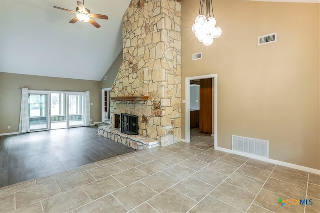 unfurnished living room featuring baseboards, visible vents, and high vaulted ceiling