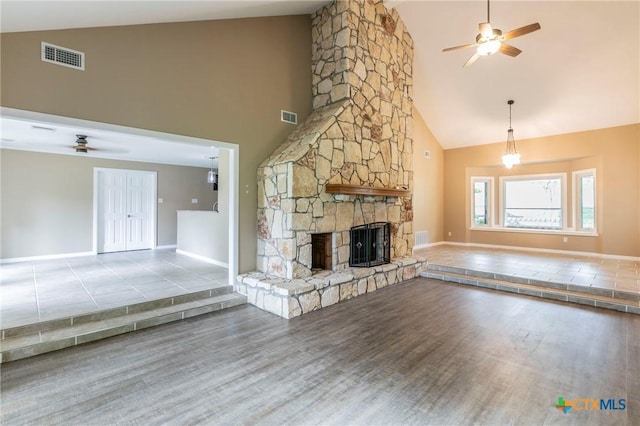 unfurnished living room with baseboards, visible vents, high vaulted ceiling, and ceiling fan