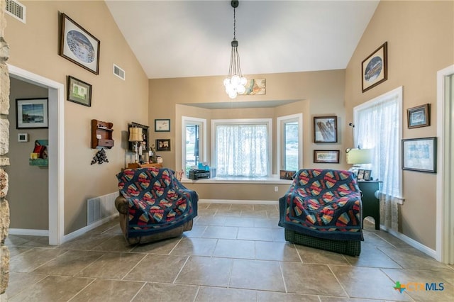 sitting room featuring a chandelier and vaulted ceiling