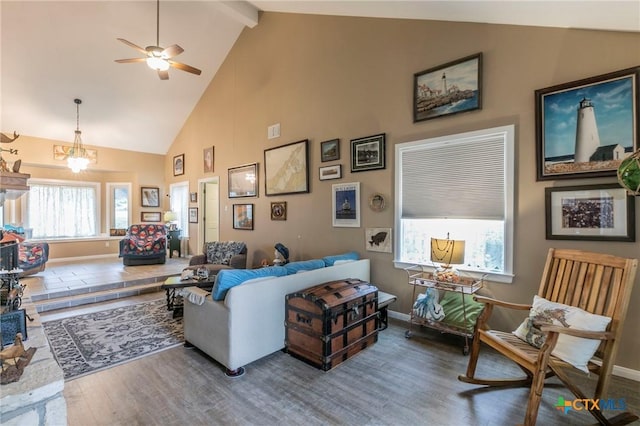 living room with ceiling fan, beamed ceiling, wood-type flooring, and high vaulted ceiling