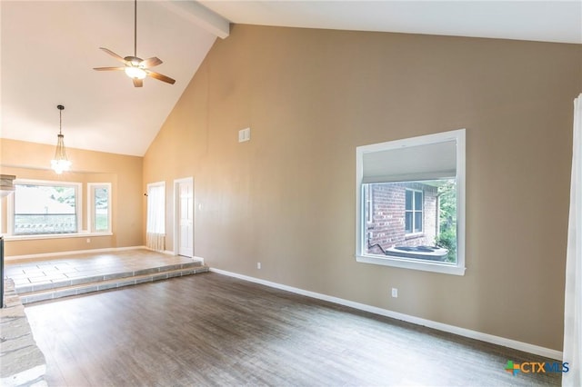 unfurnished living room with beamed ceiling, wood finished floors, high vaulted ceiling, and plenty of natural light