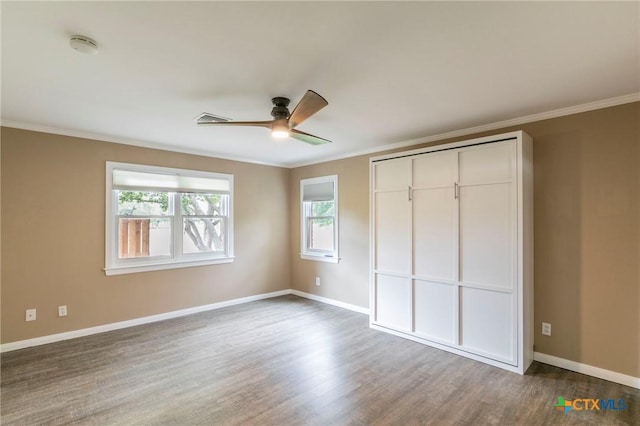 unfurnished bedroom with baseboards, dark wood finished floors, and crown molding