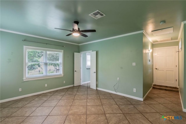 spare room with tile patterned floors, a ceiling fan, visible vents, and ornamental molding