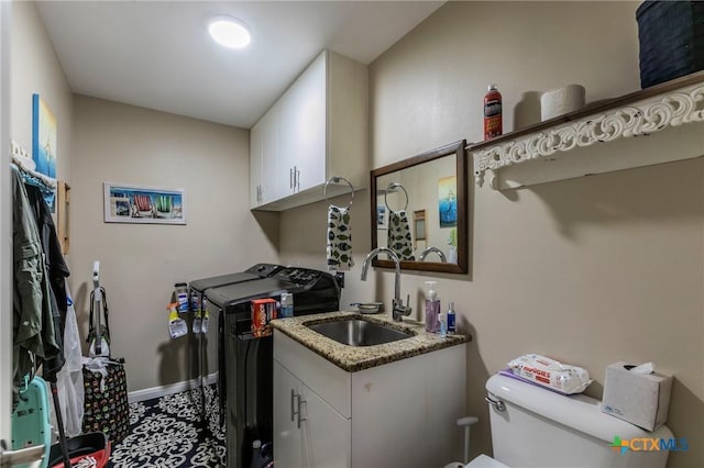 laundry room with washer and clothes dryer, sink, and cabinets