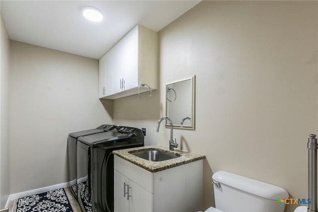 laundry room with washing machine and clothes dryer, baseboards, a sink, and laundry area