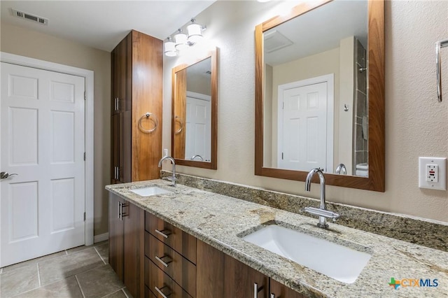 full bath with tile patterned flooring, visible vents, a sink, and double vanity
