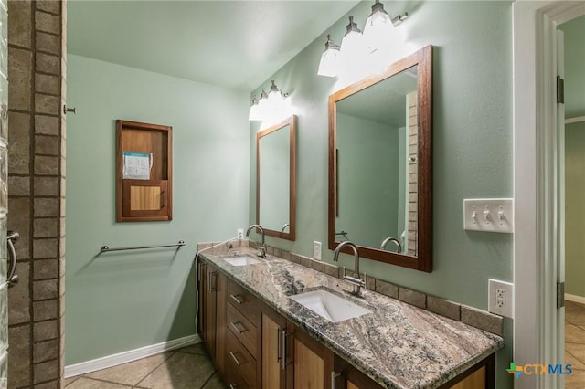 full bathroom featuring tile patterned floors, baseboards, a sink, and double vanity