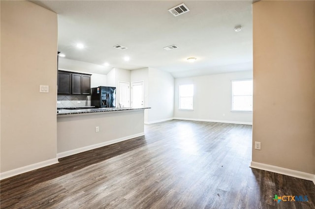 unfurnished living room featuring dark wood-style floors and visible vents