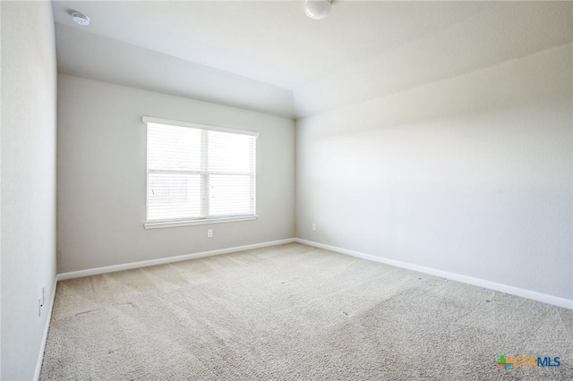 carpeted spare room featuring baseboards