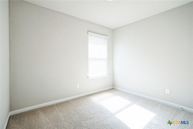 carpeted spare room with baseboards