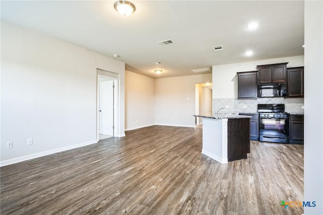 kitchen with open floor plan, visible vents, backsplash, and black appliances