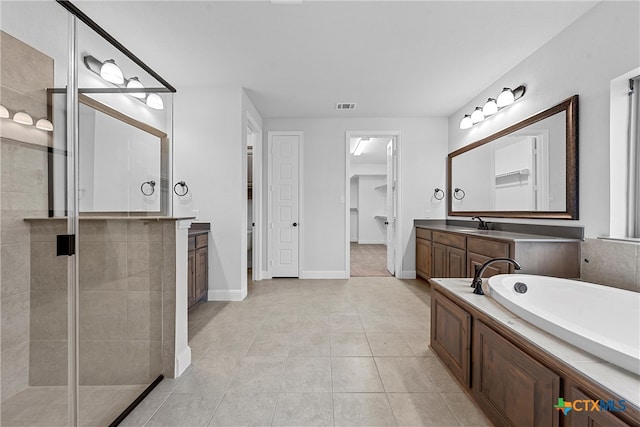 bathroom with vanity, tile patterned floors, and plus walk in shower