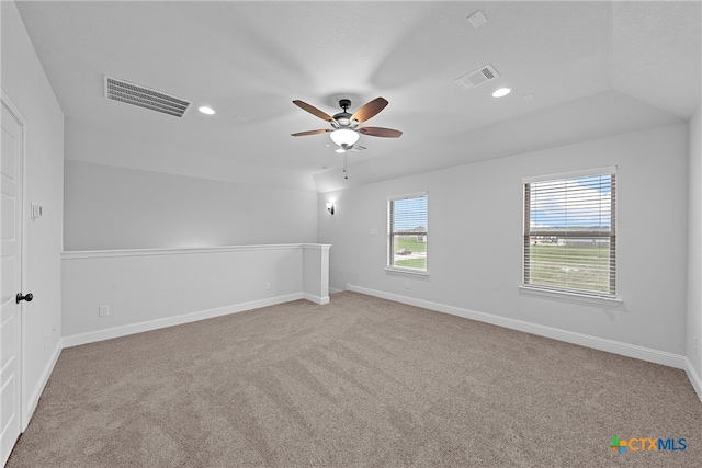 spare room featuring ceiling fan, light carpet, and lofted ceiling