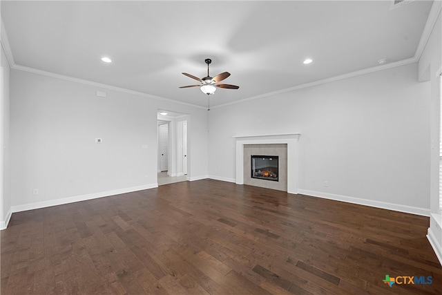 unfurnished living room featuring ceiling fan, dark hardwood / wood-style floors, a tile fireplace, and crown molding