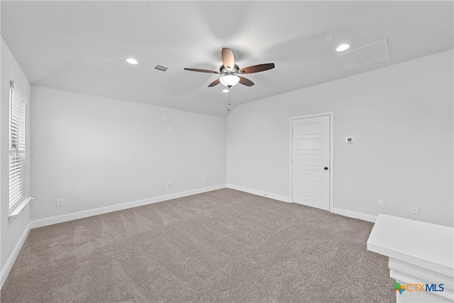 unfurnished room featuring lofted ceiling, ceiling fan, plenty of natural light, and carpet floors