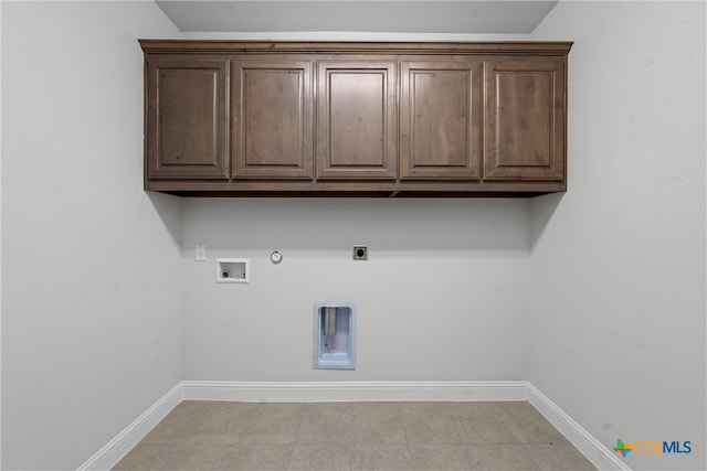 laundry area with cabinets, light tile patterned floors, electric dryer hookup, gas dryer hookup, and hookup for a washing machine