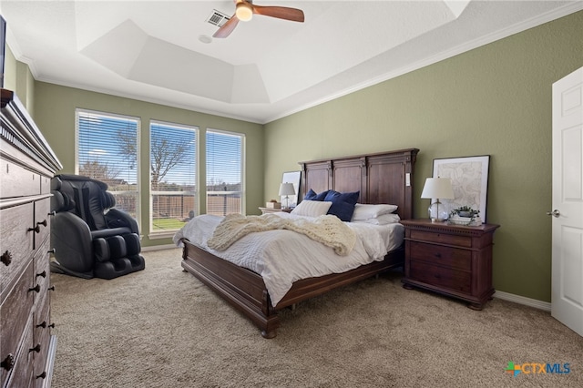 carpeted bedroom featuring a raised ceiling, crown molding, and ceiling fan